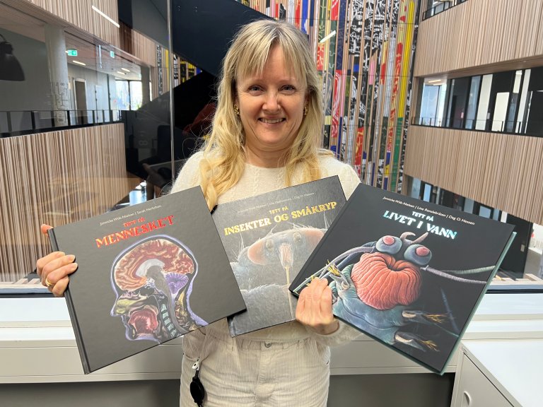 Jannicke Wiik-Nielsen med alle tre "Tett på"-bøkene hun har ny gitt ut. Foto: Bryndis Holm, Veterinærinstituttet