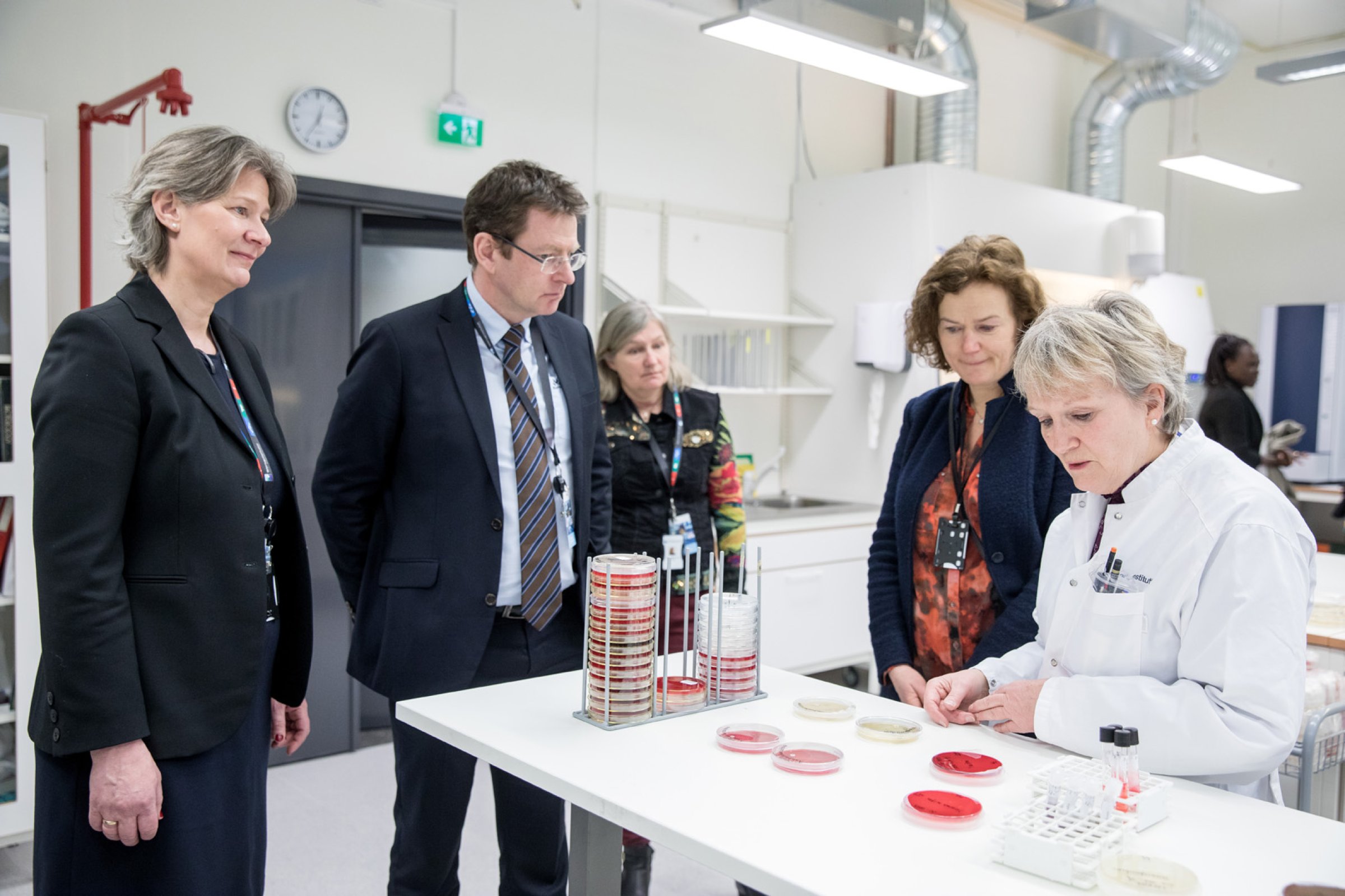 Seksjonsleder Kari Norheim (fra venstre) viser frem de nye laboratoreifasilitene til adm. dir. ved Veterinærinstituttet Gaute Lenvik med Anne-Mari Voll fra Nærings- og fiskeridepartementet. Overingeniør Kirsten Liland Bottolfsen forklarer vekst på bakterieskåler. Foto Eivind Senneset.