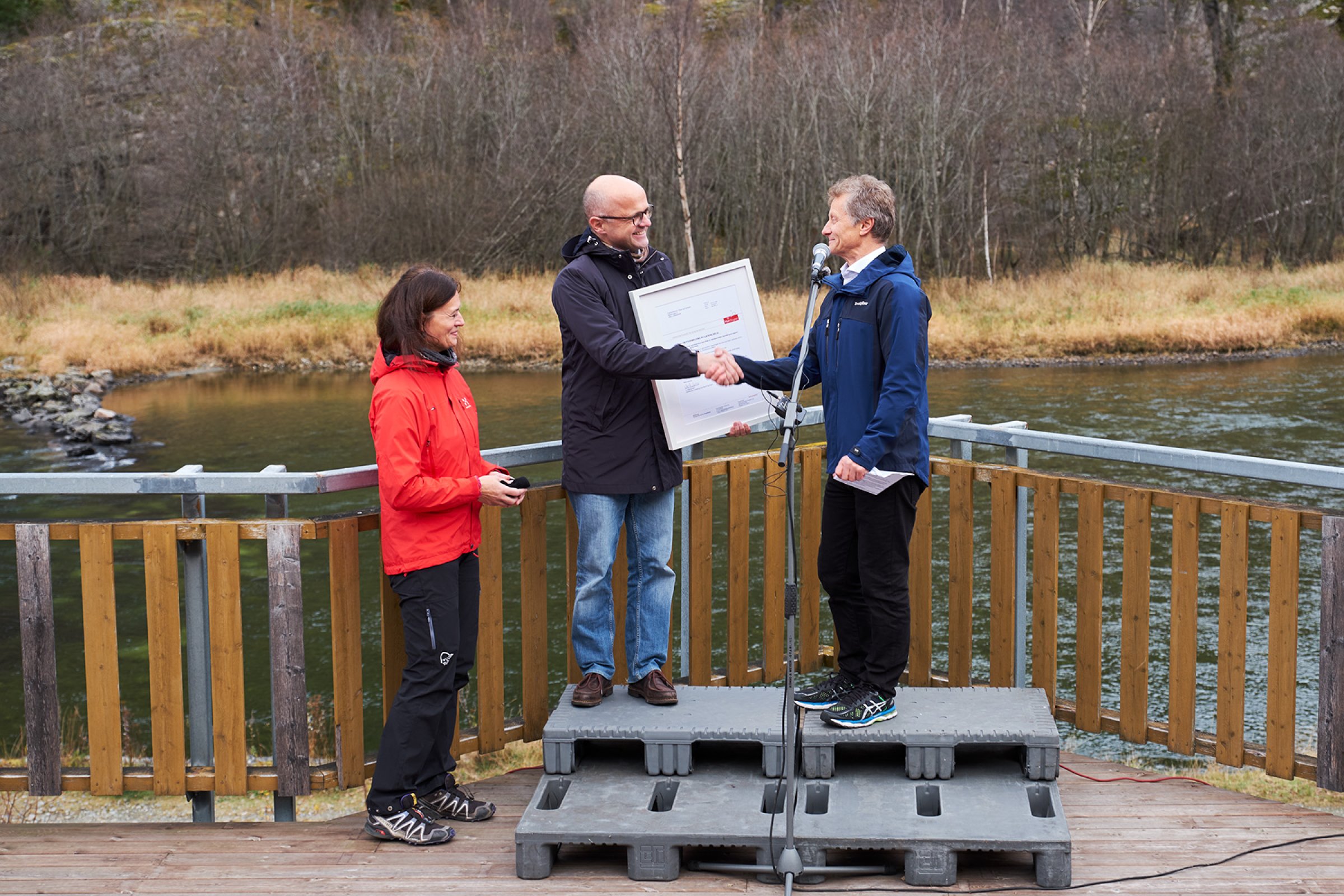 Mattilsynet overrekker bevist på at Lærdalselvi i Sogn og Fjordane er fri for lakseparasitten Gyrodactylus salaris til klima- og miljøminister Vidar Helgesen. Foto: Eivind Røhne.