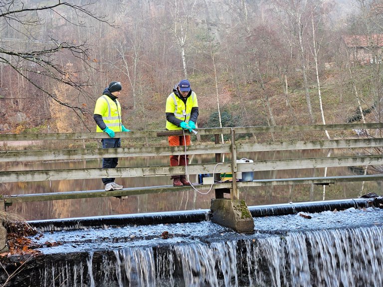 To menn på bro doserer Rotenon i Bergerelva. Foto: Helge Bardal Veterinærinstituttet