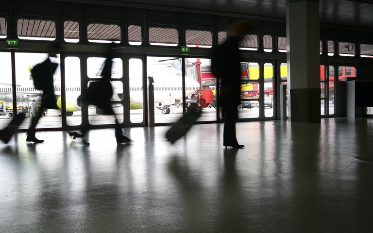 reisende med trillekoffert på flyplass